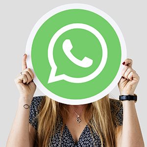 Woman holding a social network icon Woman showing a WhatsApp Messenger icon